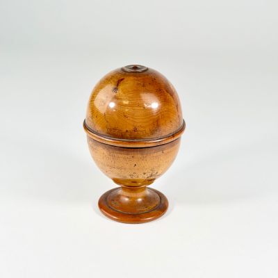 a small wooden ball on a stand on a white surface