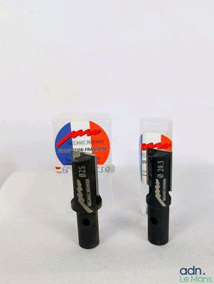 deux bouchons en plastique noir posés sur une surface blanche