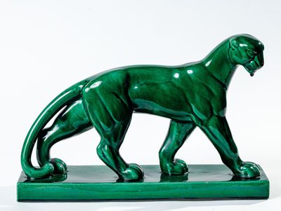 statue d'un guépard sur un socle vert, sur fond blanc