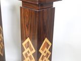 two wooden pedestals with designs on them on a white background