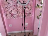 une lampe posée sur un pied devant un mur de fleurs