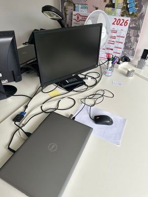 a laptop computer sitting on a desk with a monitor and a mouse