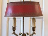 une lampe posée sur une table, avec un abat-jour rouge