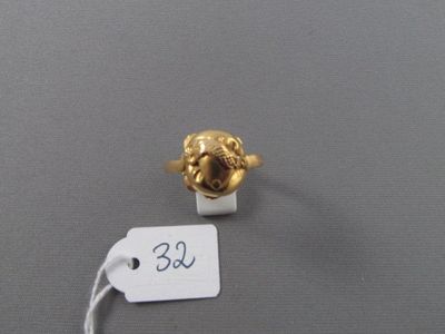 une bague en or ornée d'une tête de lion et à laquelle est attachée une étiquette de prix