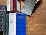 plusieurs livres posés sur une table en bois, avec un chat allongé dessus