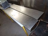 une table en métal sur laquelle est posé un ordinateur portable
