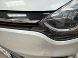 the front end of a white car with the headlights turned on