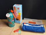 une brosse à dents, du dentifrice, un tube de dentifrice et un porte-dentifrice posés sur une table