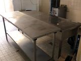 a large stainless steel table in the middle of a kitchen