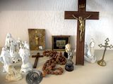 une croix, des figurines et d'autres objets religieux posés sur une table