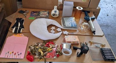 une table sur laquelle sont posés de nombreux objets, notamment des ciseaux, du ruban adhésif, de la colle, un pistolet à colle, un pistolet à colle, un pistolet à colle, un pistolet à colle, de la colle