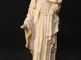 a white statue of a woman holding a baby in her arms