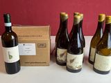 quatre bouteilles de vin sont alignées sur une table, à côté d'une boîte
