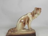 statue d'un chien assis sur un socle en bois