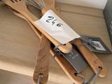 des ustensiles en bois posés sur une étagère, avec des étiquettes accrochées dessus