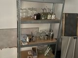 une étagère en métal sur laquelle sont posés des verres à vin et des bouteilles