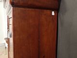 a tall wooden cabinet with a mirror on top of it