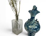 two vases with flowers in them sitting next to each other