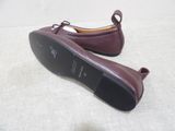 pair of burgundy leather shoes with bow ties on a white surface