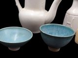 three bowls and a teapot sitting next to each other