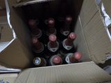 many bottles of soda in a cardboard box on the floor