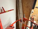 une photo d'une pièce avec une échelle et des outils accrochés au mur