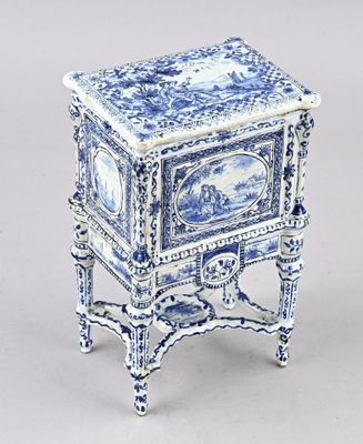 une petite table bleue et blanche sur laquelle se trouve une horloge