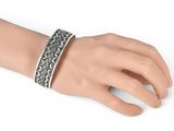 a close up of a person ' s hand wearing a silver bracelet