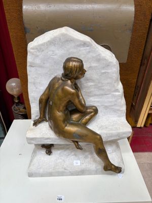 une statue de femme assise au sommet d'un rocher