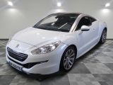 La voiture blanche est garée sur le sol à damier de la pièce.