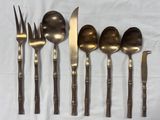 five spoons, a fork, and a knife on a table