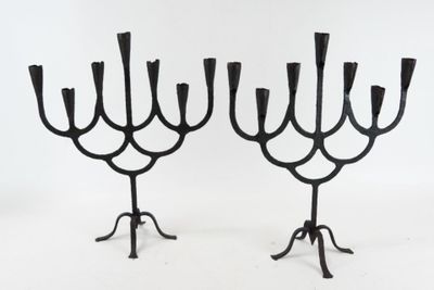 pair of black iron candelabs with candlesticks on stands
