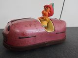a pink toy car with a little girl in it