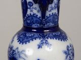 a blue and white vase sitting on top of a wooden table