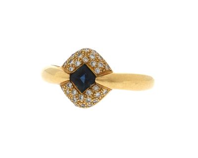 un gros plan d'une bague en or sertie d'une pierre bleue entourée de diamants