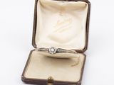 a diamond ring in a box on a white surface