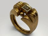 a close up of a gold ring with a square stone in the middle