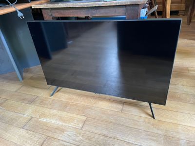 un téléviseur à écran plat posé sur un meuble au sol