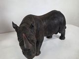 a small statue of a rhino standing on a white surface