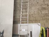 une échelle appuyée contre un mur, à côté d'une pile de bagages