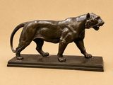 bronze statue of a lion on a marble base on a beige background