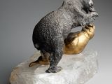 statue of a bear on a rock with a gold hand