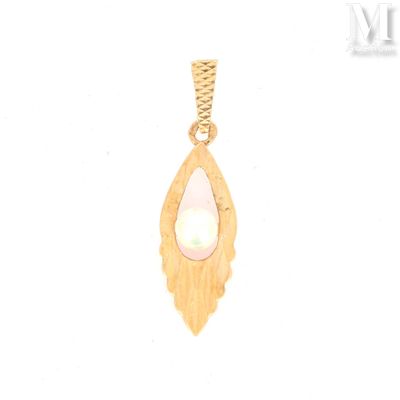a close up of a gold pendant with a pearl in it