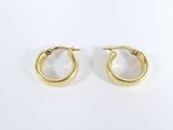 une paire de boucles d'oreilles en or sur fond blanc