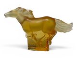 yellow glass figurine of a running horse on a white background