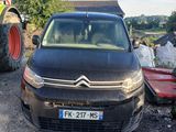 une petite voiture garée à côté d'un tracteur sur le bord de la route