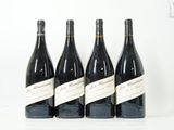 quatre bouteilles de vin sont alignées sur une surface blanche