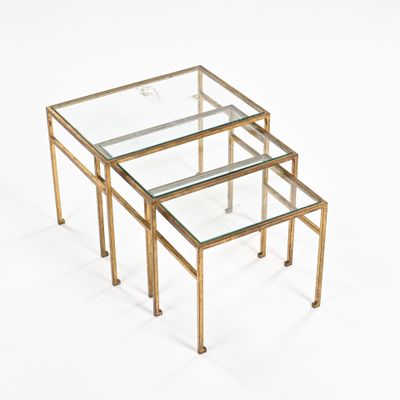 three brass and glass nesting tables on a white background