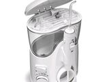 an image of a white electric toothbrush and toothpaste dispenser