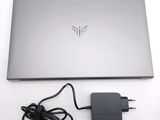 a laptop with a charger attached to it on a table